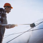 Man worker in the firld by the solar panels